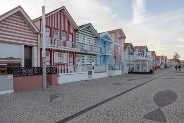 Costa Nova do Prado, Aveiro, Portekiz - 30 Ağustos 2024 Portekiz turizm sokağı sembolik çizgili ve renkli evleriyle. Günün sonunda..