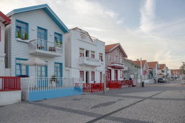Costa Nova do Prado, Aveiro, Portekiz - 30 Ağustos 2024 Portekiz turizm sokağı sembolik çizgili ve renkli evleriyle. Günün sonunda..