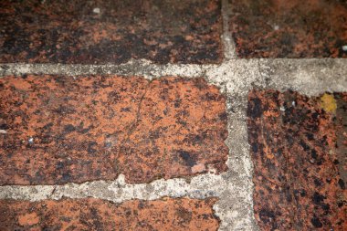 Arasında havan hatları olan eski ve yıpranmış tuğlalı bir yüzeye yakından bakmak. Desenli arkaplan ayrıntısı.