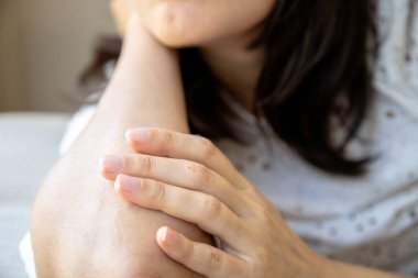 Bir kadının elinin yakın çekimi nazikçe kolunda dinleniyor, doğal güzelliği, rahatlığı ve yumuşak dokunuşu vurguluyor. Görüntü sakinliği, içselliği ve huzurlu bir anı yansıtıyor..