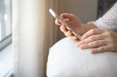 Akıllı telefonunu evinde tutan, sosyal medyayı karıştıran, internetten alışveriş yapan genç bir kadına yakın durun..