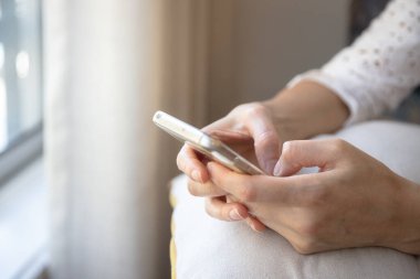 Akıllı telefonunu evinde tutan, sosyal medyayı karıştıran, internetten alışveriş yapan genç bir kadına yakın durun..