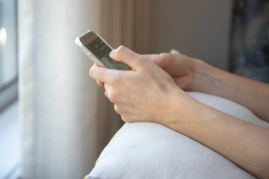 Akıllı telefonunu evinde tutan, sosyal medyayı karıştıran, internetten alışveriş yapan genç bir kadına yakın durun..