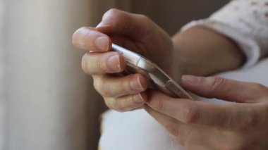 Akıllı telefonunu evinde tutan, sosyal medyada gezen, okuyan, yazan ya da internetten alışveriş yapan genç bir kadına yakın durun..