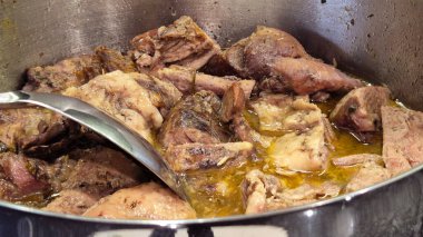 Hindi eti tencerede pişiriliyor ve tencereyi karıştırmak için kaşık kullanılıyor. Aile yemeği ya da akşam yemeği için hazırlanmış doyurucu ve lezzetli bir yemek..