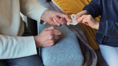 Bir çocuk hasarlı bir emziği bırakmakta tereddüt eder, eskimesine rağmen konfora tutunur. Bağlılık ve değişim ihtiyacı arasındaki mücadeleyi yakaladığı an duygusal bağımlılığı sembolize eder..