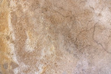 Kaba, yıpranmış, doğal dokuları ve toprak tonlarıyla kumtaşı yüzeyine yakın çekim. Gözenekli yapı ve mineral yatakları zamanın ve jeolojik dönüşümün geçişini ortaya çıkarıyor..