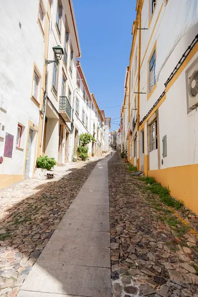 Güneşli bir öğleden sonra Portekiz 'in Castelo de Vide kentinde, tarihi Alentejo köyü boyunca esen sakin bir kaldırım taşı caddesi geleneksel beyaz boyalı evleri ve sarı detayları gözler önüne seriyor..