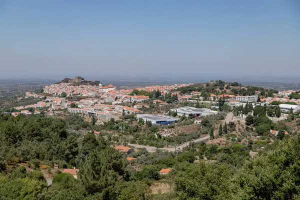 Portekiz 'in Alentejo kentindeki tarihi bir köy olan Castelo de Vide' nin panoramik manzarası, ortaçağ şatosu ve kırmızı çatılı beyaz evleri aydınlatarak, manzaralı bir yaz günü çekildi..