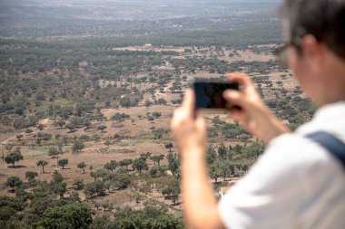 Bir turist, güneşli bir yaz günü Fonte dos Carvoeiros manzarasından Carreiras, Portalegre, Alentejo, Portekiz 'in panoramik manzarasını yakalar ve kırsal manzaraya hayran kalır..