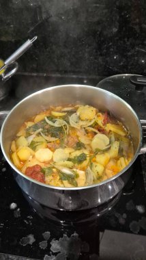 Caldeirada de bacalhau olarak bilinen geleneksel Portekiz morina balığı güveci, dilimlenmiş patates, soğan, domates, biber, otlar ve zeytinyağı ile birlikte paslanmaz çelik bir tencerede hazırlandı.