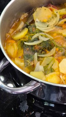 Caldeirada de bacalhau olarak bilinen geleneksel Portekiz morina balığı güveci, dilimlenmiş patates, soğan, domates, biber, otlar ve zeytinyağı ile birlikte paslanmaz çelik bir tencerede hazırlandı.