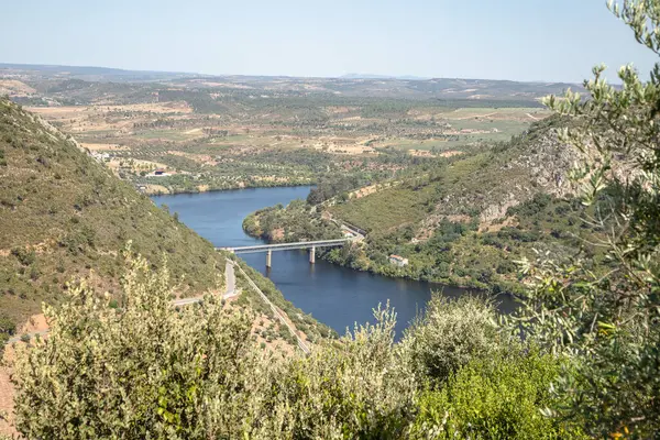 Ağustosta yemyeşil tepelerden akan kıvrımlı Tejo Nehri 'nin nefes kesici hava manzarası. Portekiz, Vila Velha de Rodao 'daki geniş manzaranın sakin ve panoramik görüntüsü.