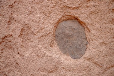 Portekiz 'deki tarihi ya da kırsal bir yapıdan, doğal ışık altında çekilmiş dairesel bir taşla eski dokulu bir kerpiç duvarının ayrıntıları..