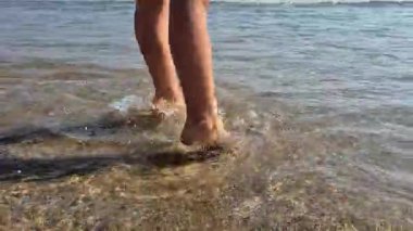 Neşeli bir çocuk güneşli bir yaz gününde Portekiz 'in Matosinhos Sahili' nde sığ dalgaların üzerinden atlıyor. Havada yakalanan bu an enerjiyi, özgürlüğü ve eğlenceli deniz macerasını yansıtıyor..