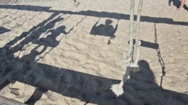 Sahil kenarındaki salıncaklardaki çocukların gölgelerinde geçen sonsuz çocukluk sevinci, özgürlük, hayal gücü ve yeri aşan tasasız anlar için mükemmel bir metafor..