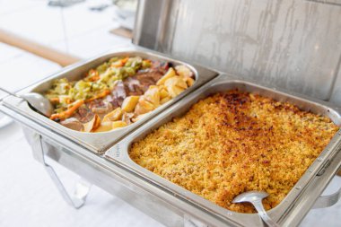Açık büfe öğle yemeği bir yemek organizasyonunda servis edilir. Sıcak yemek tabakları kızarmış patates ve sebzeli bir et yemeği ve fırında balık yemeği içerir. Toplamak için ideal.