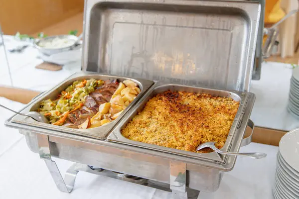 Açık büfe öğle yemeği bir yemek organizasyonunda servis edilir. Sıcak yemek tabakları kızarmış patates ve sebzeli bir et yemeği ve fırında balık yemeği içerir. Toplamak için ideal.