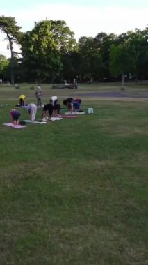ENGLAND, LUTON TOWN - 04th April 2022: Genç İngiliz Kadınlardan oluşan bir grup, Wardown Halk Parkı Yüksek Açılı Görüntü Parkı 'nda egzersiz yapıyor. Luton Kasabası 'nda Parlak Güneşli Gün