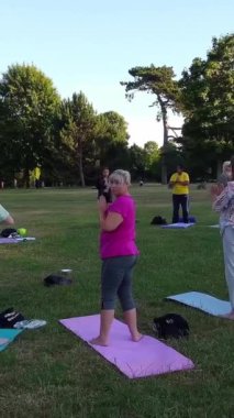 ENGLAND, LUTON TOWN - 04th April 2022: Genç İngiliz Kadınlardan oluşan bir grup, Wardown Halk Parkı Yüksek Açılı Görüntü Parkı 'nda egzersiz yapıyor. Luton Kasabası 'nda Parlak Güneşli Gün