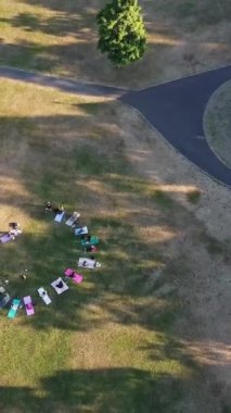 ENGLAND, LUTON TOWN - 04th April 2022: Genç İngiliz Kadınlardan oluşan bir grup, Wardown Halk Parkı Yüksek Açılı Görüntü Parkı 'nda egzersiz yapıyor. Luton Kasabası 'nda Parlak Güneşli Gün