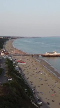 BİRLİK KINGDOM, BOURNEMOUTH BEACH - 18 Temmuz 2022: insanlar yaz tatillerinde eğleniyorlar. Yüksek Açı Drone Kamera Görünümü