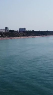 BİRLİK KINGDOM, BOURNEMOUTH BEACH - 18 Temmuz 2022: insanlar yaz tatillerinde eğleniyorlar. Yüksek Açı Drone Kamera Görünümü