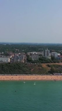 BİRLİK KINGDOM, BOURNEMOUTH BEACH - 18 Temmuz 2022: insanlar yaz tatillerinde eğleniyorlar. Yüksek Açı Drone Kamera Görünümü