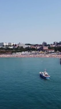 BİRLİK KINGDOM, BOURNEMOUTH BEACH - 18 Temmuz 2022: insanlar yaz tatillerinde eğleniyorlar. Yüksek Açı Drone Kamera Görünümü