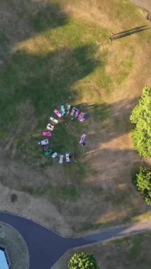 ENGLAND, LUTON TOWN - 04th April 2022: Genç İngiliz Kadınlardan oluşan bir grup, Wardown Halk Parkı Yüksek Açılı Görüntü Parkı 'nda egzersiz yapıyor. Luton Kasabası 'nda Parlak Güneşli Gün