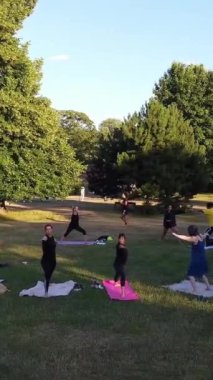 ENGLAND, LUTON TOWN - 04th April 2022: Genç İngiliz Kadınlardan oluşan bir grup, Wardown Halk Parkı Yüksek Açılı Görüntü Parkı 'nda egzersiz yapıyor. Luton Kasabası 'nda Parlak Güneşli Gün