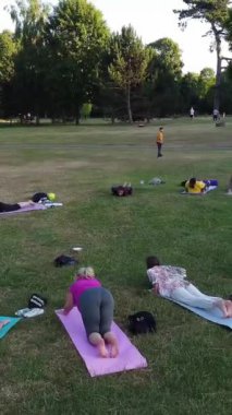 ENGLAND, LUTON TOWN - 04th April 2022: Genç İngiliz Kadınlardan oluşan bir grup, Wardown Halk Parkı Yüksek Açılı Görüntü Parkı 'nda egzersiz yapıyor. Luton Kasabası 'nda Parlak Güneşli Gün