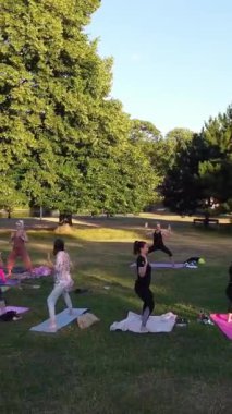 ENGLAND, LUTON TOWN - 04th April 2022: Genç İngiliz Kadınlardan oluşan bir grup, Wardown Halk Parkı Yüksek Açılı Görüntü Parkı 'nda egzersiz yapıyor. Luton Kasabası 'nda Parlak Güneşli Gün