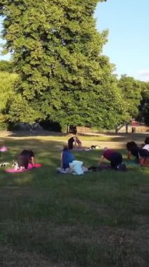 ENGLAND, LUTON TOWN - 04th April 2022: Genç İngiliz Kadınlardan oluşan bir grup, Wardown Halk Parkı Yüksek Açılı Görüntü Parkı 'nda egzersiz yapıyor. Luton Kasabası 'nda Parlak Güneşli Gün