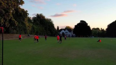 İngiltere, İngiltere, LUTON - 11 Mart 2023: Şehir parkında futbol oynayan gençlerin yavaş çekim görüntüleri 