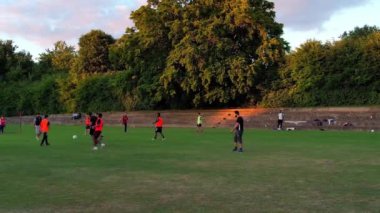 İngiltere, İngiltere, LUTON - 11 Mart 2023: Şehir parkında futbol oynayan gençlerin yavaş çekim görüntüleri 