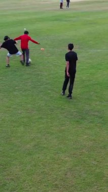 İngiltere, İngiltere, LUTON - 11 Mart 2023: Şehir parkında futbol oynayan gençlerin yavaş çekim görüntüleri 