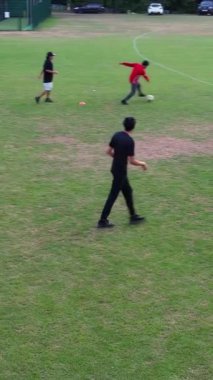 İngiltere, İngiltere, LUTON - 11 Mart 2023: Şehir parkında futbol oynayan gençlerin yavaş çekim görüntüleri 