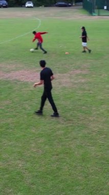 İngiltere, İngiltere, LUTON - 11 Mart 2023: Şehir parkında futbol oynayan gençlerin yavaş çekim görüntüleri 