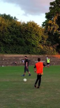 İngiltere, İngiltere, LUTON - 11 Mart 2023: Şehir parkında futbol oynayan gençlerin yavaş çekim görüntüleri 