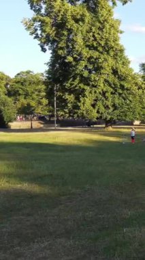 ENGLAND, LUTON TOWN - 04th April 2022: Genç İngiliz Kadınlardan oluşan bir grup, Wardown Halk Parkı Yüksek Açılı Görüntü Parkı 'nda egzersiz yapıyor. Luton Kasabası 'nda Parlak Güneşli Gün