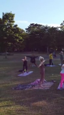 ENGLAND, LUTON TOWN - 04th April 2022: Genç İngiliz Kadınlardan oluşan bir grup, Wardown Halk Parkı Yüksek Açılı Görüntü Parkı 'nda egzersiz yapıyor. Luton Kasabası 'nda Parlak Güneşli Gün