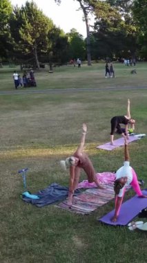 ENGLAND, LUTON TOWN - 04th April 2022: Genç İngiliz Kadınlardan oluşan bir grup, Wardown Halk Parkı Yüksek Açılı Görüntü Parkı 'nda egzersiz yapıyor. Luton Kasabası 'nda Parlak Güneşli Gün