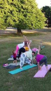 ENGLAND, LUTON TOWN - 04th April 2022: Genç İngiliz Kadınlardan oluşan bir grup, Wardown Halk Parkı Yüksek Açılı Görüntü Parkı 'nda egzersiz yapıyor. Luton Kasabası 'nda Parlak Güneşli Gün