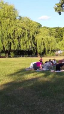 ENGLAND, LUTON TOWN - 04th April 2022: Genç İngiliz Kadınlardan oluşan bir grup, Wardown Halk Parkı Yüksek Açılı Görüntü Parkı 'nda egzersiz yapıyor. Luton Kasabası 'nda Parlak Güneşli Gün