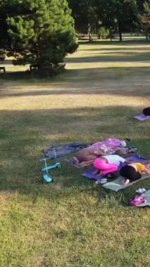 ENGLAND, LUTON TOWN - 04th April 2022: Genç İngiliz Kadınlardan oluşan bir grup, Wardown Halk Parkı Yüksek Açılı Görüntü Parkı 'nda egzersiz yapıyor. Luton Kasabası 'nda Parlak Güneşli Gün