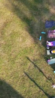 ENGLAND, LUTON TOWN - 04th April 2022: Genç İngiliz Kadınlardan oluşan bir grup, Wardown Halk Parkı Yüksek Açılı Görüntü Parkı 'nda egzersiz yapıyor. Luton Kasabası 'nda Parlak Güneşli Gün