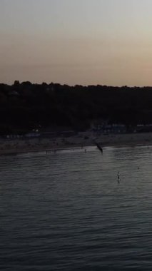 İngiltere 'nin Bournemouth Sahili' nde eğlenen ve rahatlatan insanlar.
