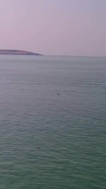 BİRLİK KINGDOM, BOURNEMOUTH BEACH - 18 Temmuz 2022: insanlar yaz tatillerinde eğleniyorlar. Yüksek Açı Drone Kamera Görünümü