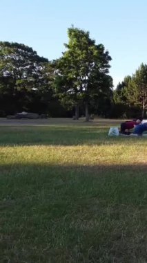 ENGLAND, LUTON TOWN - 04th April 2022: Genç İngiliz Kadınlardan oluşan bir grup, Wardown Halk Parkı Yüksek Açılı Görüntü Parkı 'nda egzersiz yapıyor. Luton Kasabası 'nda Parlak Güneşli Gün